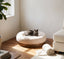 Cat resting in a beige round plush pet bed