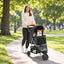 Black folding pet stroller with a small dog on a park path