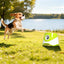 Green automatic dog ball launcher with a dog playing outdoors