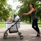 Gray foldable pet stroller with a small dog on a park path