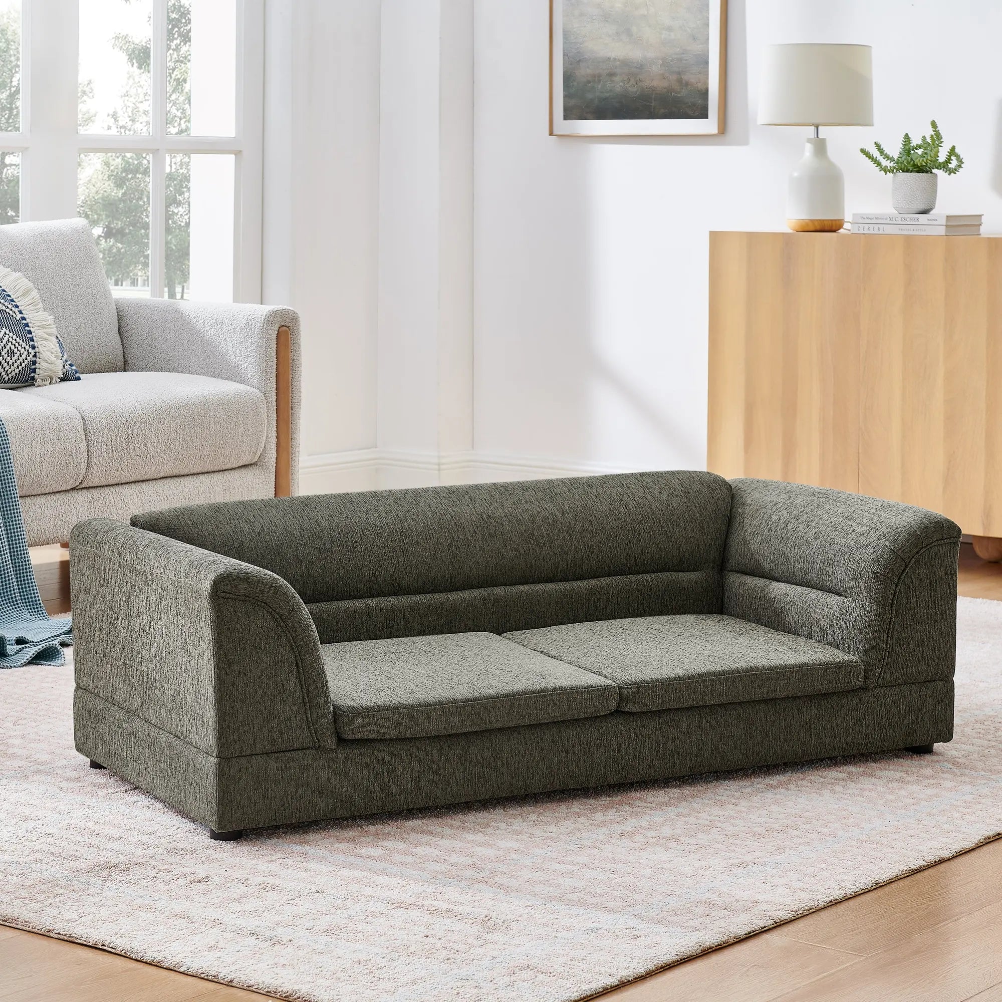 Oversized dark gray linen dog sofa clean room view