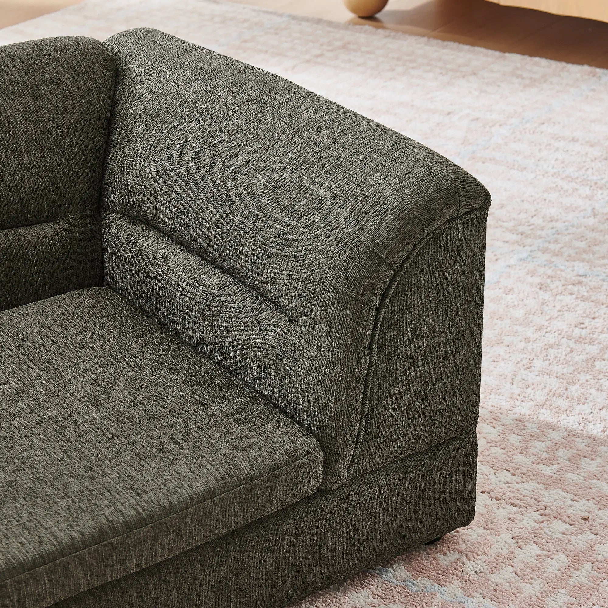 Curved padded armrest on dark gray dog sofa