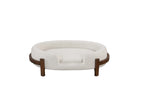 Beige oval dog bed with fabric cushion and solid wood frame — lifestyle view