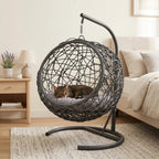 Gray rattan-style hanging cat swing bed with cushion and stand — lifestyle view