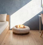 Pet curled up in a round beige bed