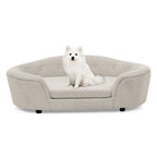 Beige oval dog sofa bed with a small white dog