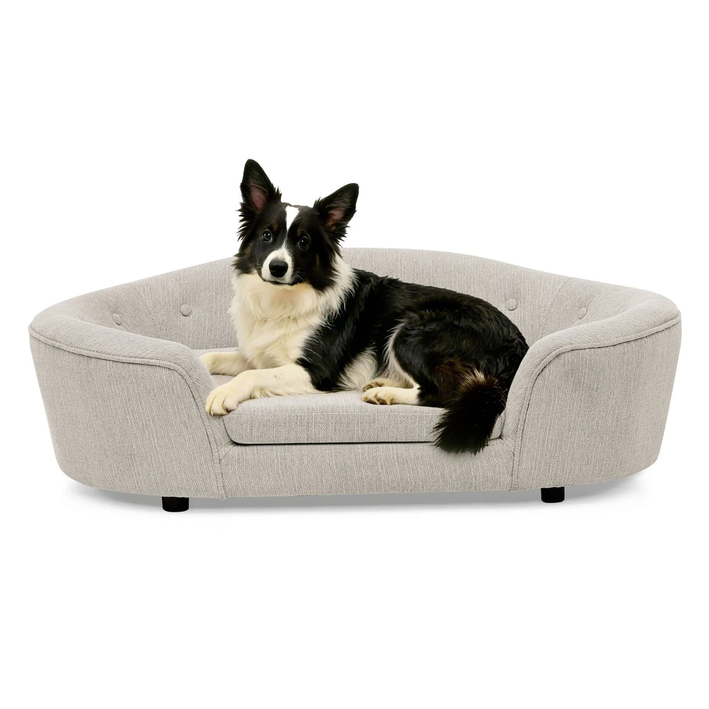Beige oval dog sofa bed with a black and white dog