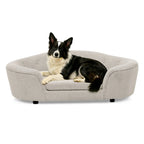 Beige oval dog sofa bed with a black and white dog