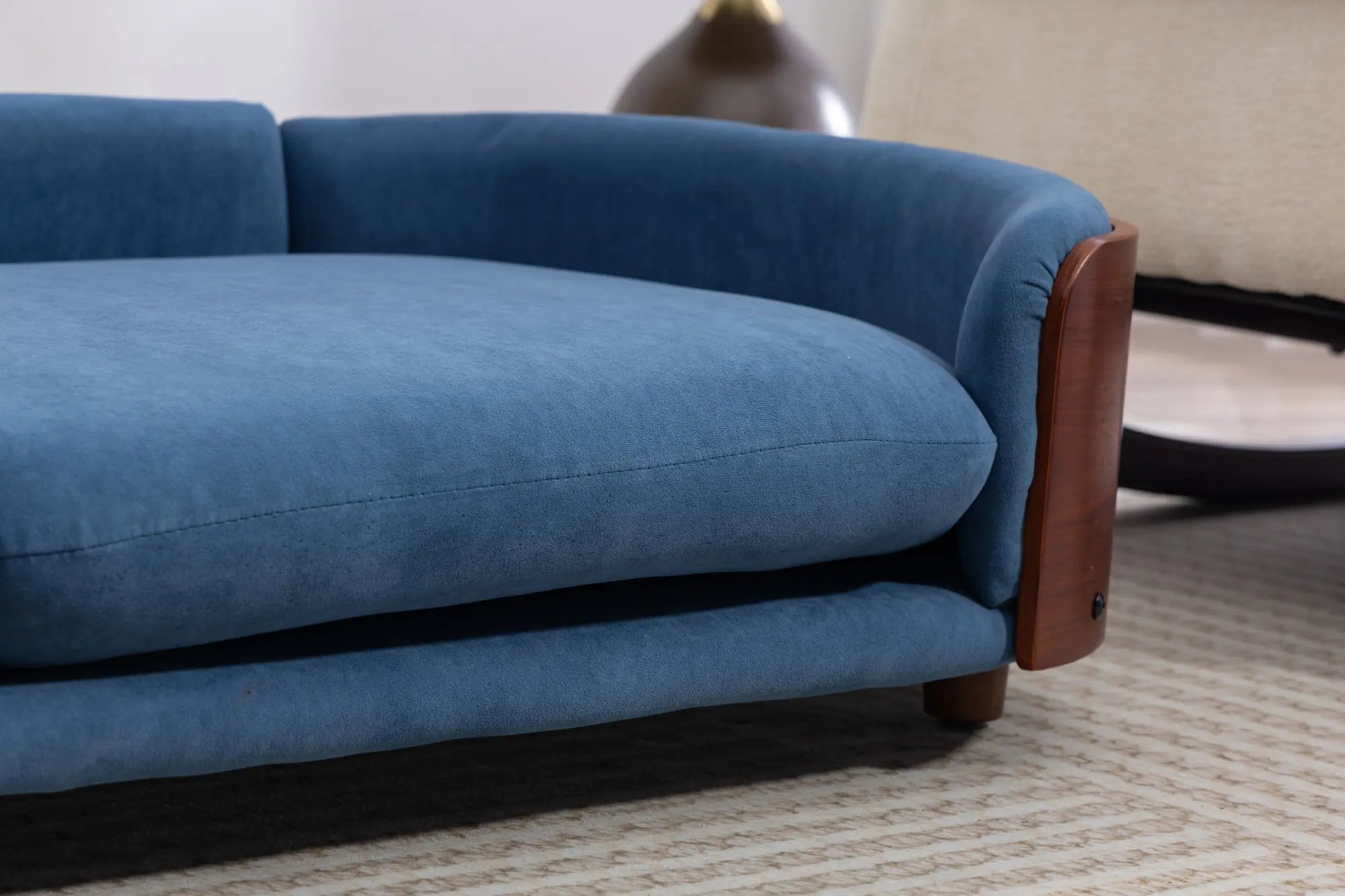 Velvet cushion and wooden foot detail on a dog sofa