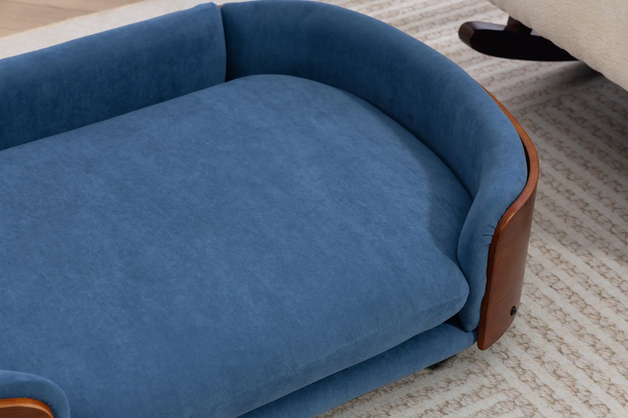 Blue velvet cushion close-up on a wooden dog sofa