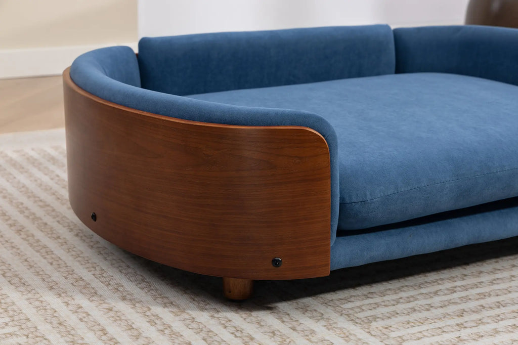 Angled close-up of a blue velvet wooden dog sofa