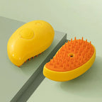 Yellow mango-shaped cat mist grooming brush with orange bristles