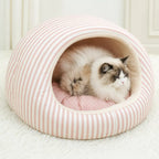 Cat resting inside a pink striped pet cave bed