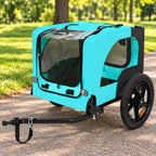 Light blue folding dog bike trailer parked on a park path