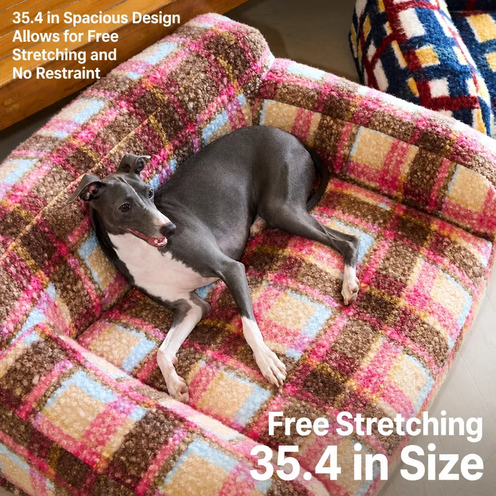 Dog reclining in pink plaid pet sofa