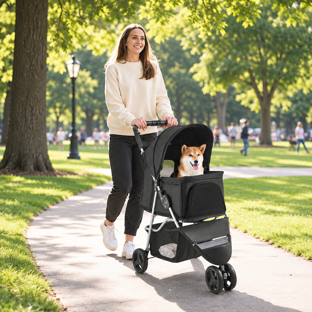 Black folding pet stroller with a small dog on a park path