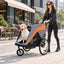 Gray and orange pet trailer used as a stroller on a sidewalk
