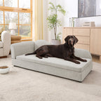 Beige upholstered dog sofa — dog resting on sofa